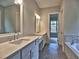 Bathroom featuring double vanities, tile flooring, and a luxurious bathtub at 3730 Reserve Overlook (Lot 8) Way, Cumming, GA 30041