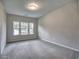 Well-lit bedroom featuring neutral walls, plush carpet, and a large window with outdoor views at 3730 Reserve Overlook (Lot 8) Way, Cumming, GA 30041