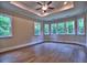 Spacious bedroom with hardwood floors, tray ceiling, a ceiling fan, and lots of natural light at 3730 Reserve Overlook (Lot 8) Way, Cumming, GA 30041