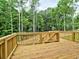 Wooden deck with a wood railing overlooks green grass and a wooded area at 3730 Reserve Overlook (Lot 8) Way, Cumming, GA 30041