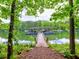 Picturesque lakeside view showcases a covered boat dock surrounded by vibrant greenery at 3730 Reserve Overlook (Lot 8) Way, Cumming, GA 30041