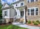 Charming entrance with stone accents, a covered porch, and a well-manicured landscape at 3730 Reserve Overlook (Lot 8) Way, Cumming, GA 30041