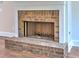Close-up of a brick fireplace with black metal screen in a neutral-toned room with light wood floors at 3730 Reserve Overlook (Lot 8) Way, Cumming, GA 30041