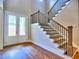 Elegant foyer featuring hardwood floors, a staircase with dark railings, and a double-door entrance at 3730 Reserve Overlook (Lot 8) Way, Cumming, GA 30041