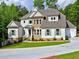 Two-story home with a combination of siding and stone, a well-kept lawn, and long driveway at 3730 Reserve Overlook (Lot 8) Way, Cumming, GA 30041