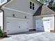 Two car garage with white doors and black hardware with exterior lights and gray siding at 3730 Reserve Overlook (Lot 8) Way, Cumming, GA 30041