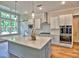 Modern kitchen with white cabinets, stainless steel appliances, an island, and hardwood floors at 3730 Reserve Overlook (Lot 8) Way, Cumming, GA 30041