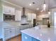 A kitchen featuring stainless steel appliances, white cabinets, stylish pendant lighting, and a spacious center island at 3730 Reserve Overlook (Lot 8) Way, Cumming, GA 30041