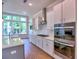 Bright kitchen features modern appliances, sleek countertops, and a large window overlooking the trees at 3730 Reserve Overlook (Lot 8) Way, Cumming, GA 30041