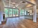 Open-concept living room with a fireplace, hardwood floors, large windows and a view of the kitchen at 3730 Reserve Overlook (Lot 8) Way, Cumming, GA 30041