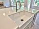 Close-up of a farm sink with stainless faucet set in light colored quartz countertop at 3730 Reserve Overlook (Lot 8) Way, Cumming, GA 30041