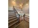 Beautiful staircase with wood steps, wrought iron railing, and a clear view of the open-concept living space below at 3730 Reserve Overlook (Lot 8) Way, Cumming, GA 30041