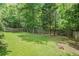Expansive backyard with a lush lawn, mature trees, and a privacy fence at 734 Kilkenny Cir, Lithonia, GA 30058