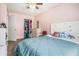 Charming bedroom featuring pink walls, wood floors, and a closet for ample storage at 734 Kilkenny Cir, Lithonia, GA 30058