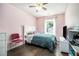 Cozy bedroom with pink walls, ceiling fan, and natural light from the window at 734 Kilkenny Cir, Lithonia, GA 30058