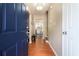 Inviting home foyer featuring wood floors, neutral walls, a modern light fixture and blue front door at 734 Kilkenny Cir, Lithonia, GA 30058