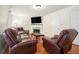 Living room boasts hardwood floors, fireplace, and brown leather seating, perfect for relaxation at 734 Kilkenny Cir, Lithonia, GA 30058