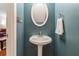 The powder room features a pedestal sink, oval mirror, blue walls, and a white towel at 734 Kilkenny Cir, Lithonia, GA 30058