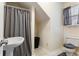 Well-lit bathroom with a toilet, sink, shower with curtain, and storage space at 836 Palmetto Tyrone Rd, Sharpsburg, GA 30277