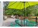 Outdoor deck with furniture, umbrella, and views of the wooded backyard at 836 Palmetto Tyrone Rd, Sharpsburg, GA 30277