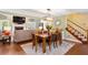 Inviting dining area features an elegant dining table, hardwood floors, and a fireplace in the adjacent living room at 836 Palmetto Tyrone Rd, Sharpsburg, GA 30277