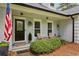 Charming front porch with an American flag, cozy seating, and manicured bushes enhancing the curb appeal at 836 Palmetto Tyrone Rd, Sharpsburg, GA 30277