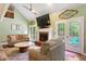 A cozy living room featuring a fireplace, modern ceiling fan, and access to outdoor views at 836 Palmetto Tyrone Rd, Sharpsburg, GA 30277
