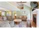 Sunlit living room with hardwood floors, fireplace, and open layout to an upstairs loft area at 836 Palmetto Tyrone Rd, Sharpsburg, GA 30277
