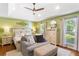 Inviting main bedroom with tray ceiling, accent wall, a ceiling fan, and lots of natural light at 836 Palmetto Tyrone Rd, Sharpsburg, GA 30277