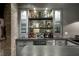 Wet bar area with stone counters, bar fridge and shelves and cabinets for storage and display at 1849 Rock Springs Ne Ln, Atlanta, GA 30324