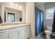 A bathroom with a marble vanity, white cabinets, and a blue shower curtain at 1849 Rock Springs Ne Ln, Atlanta, GA 30324