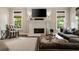 Cozy living room featuring a fireplace with mounted TV, large sofa, and chair by the windows at 1849 Rock Springs Ne Ln, Atlanta, GA 30324
