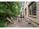 Stone patio with wood chairs, a fire pit, and a stainless steel grill, adjacent to a brick home exterior at 1849 Rock Springs Ne Ln, Atlanta, GA 30324