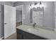 Bathroom featuring a modern vanity, large mirror, and stylish lighting fixtures at 2401 Phillips Rd, Lithonia, GA 30058