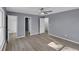 Spacious bedroom with multiple doorways, modern lighting, and hardwood-style flooring at 2401 Phillips Rd, Lithonia, GA 30058