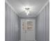Inviting entryway featuring wood paneling, textured ceiling, and modern light fixture at 2401 Phillips Rd, Lithonia, GA 30058