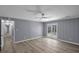 Spacious living room with light wood flooring, ceiling fan and double glass doors to the back yard at 2401 Phillips Rd, Lithonia, GA 30058