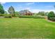 Expansive backyard featuring a well-manicured lawn, mature landscaping, and a covered patio at 2455 Ivey Oaks Rd, Cumming, GA 30041