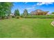 Large backyard showcasing a lush lawn, mature trees, and partially concealed home exterior at 2455 Ivey Oaks Rd, Cumming, GA 30041