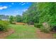 Backyard featuring a well-maintained lawn, wooden fence, playset, and lush foliage at 2455 Ivey Oaks Rd, Cumming, GA 30041