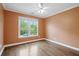 Bedroom featuring hardwood floors, a ceiling fan, and a window with neighborhood views at 2455 Ivey Oaks Rd, Cumming, GA 30041