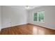 Bright bedroom with hardwood floors, a ceiling fan, and a large window with outdoor views at 2455 Ivey Oaks Rd, Cumming, GA 30041