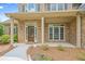 Charming front porch with stone accents and a decorative front door at 2455 Ivey Oaks Rd, Cumming, GA 30041