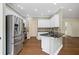 A well-lit kitchen features stainless steel appliances, granite countertops, and white cabinets at 2455 Ivey Oaks Rd, Cumming, GA 30041