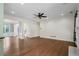 Spacious living room with hardwood floors, ceiling fan, and easy access to the entryway, dining room, and kitchen at 2455 Ivey Oaks Rd, Cumming, GA 30041