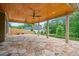 Covered stone patio featuring a wooden ceiling with dual fans and backyard views at 2455 Ivey Oaks Rd, Cumming, GA 30041