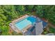 Aerial view of community pool with lounge chairs and umbrella tables surrounded by mature trees at 2455 Ivey Oaks Rd, Cumming, GA 30041