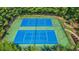Overhead view of fenced tennis courts, mature trees, and an adjacent play area at 2455 Ivey Oaks Rd, Cumming, GA 30041