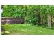 A view of the grass and a fence on the back of the property, with a wooded area in the background at 556 Poplar Bnd, Canton, GA 30114