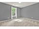 This bedroom features neutral walls, carpet flooring, and a large window at 556 Poplar Bnd, Canton, GA 30114